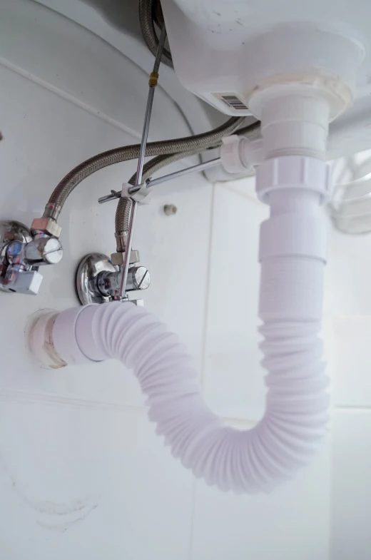 a white sink sitting under a bathroom faucet, plasticien, steam pipes, rubber hose, white mechanical details, garbage