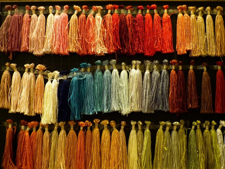 a wall filled with lots of tassels of different colors, a cross stitch, by Anita Kunz, flickr, arts and crafts movement, flowing silk sheets, color chart, grain”, on display ”