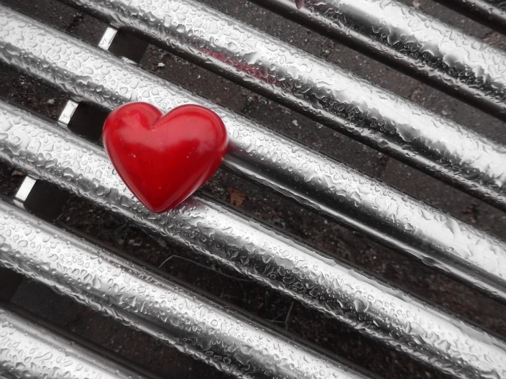 a red heart sitting on top of a metal grill, a picture, inspired by János Valentiny, mid shot photo