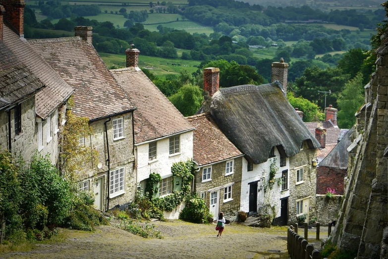 a person walking up a steep hill in a village, by Edward Corbett, thatched roofs, beautiful english countryside, movie set”