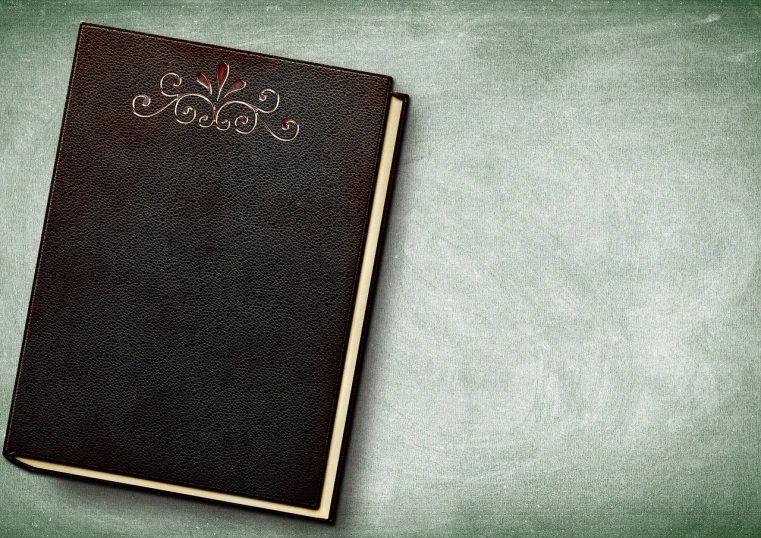 a brown book sitting on top of a green table, an album cover, trending on pixabay, baroque, blackboard, background image, colorized background, abstract black leather