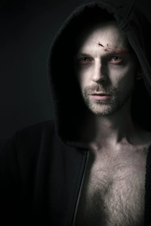 a close up of a person wearing a hoodie, a character portrait, by Adam Marczyński, shutterstock, handsome male vampire, zombie with white eyes, thin scar on his forehead, dark photo