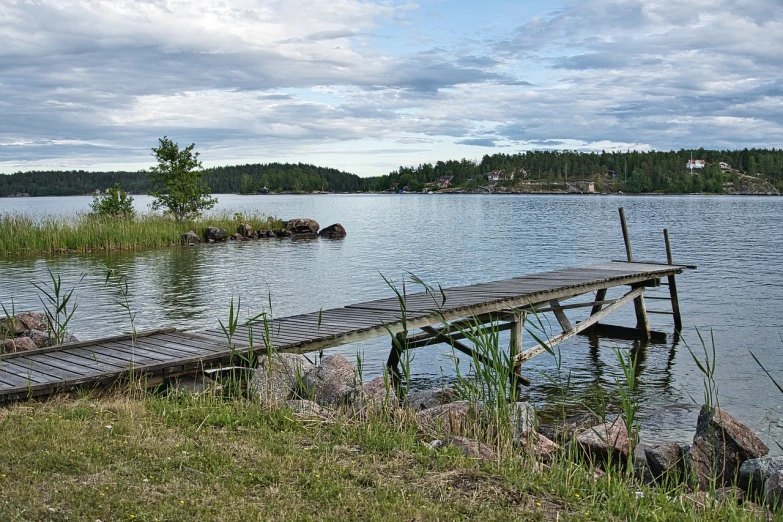 a dock in the middle of a body of water, by Eero Järnefelt, shutterstock, hurufiyya, partly sunken! in the lake!, swedish countryside, stock photo, ede laszlo