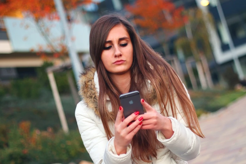 a woman is looking at her cell phone, by John Luke, pexels, happening, girl with brown hair, warm coloured, message, 1 2 9 7