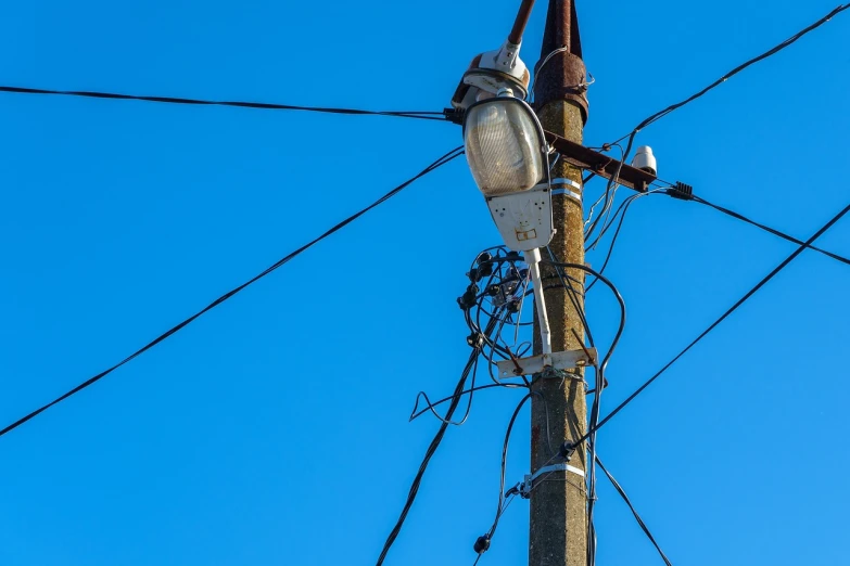 a close up of a telephone pole with wires, shutterstock, street lamp, broken down, high angle close up shot, blue sky