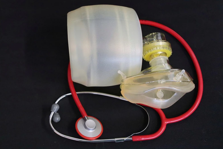 a medical device with a stethoscope attached to it, by James Warhola, bag - valve mask, resin, inner glow, bottom - view