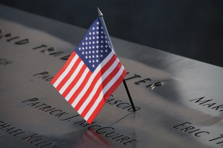 a small american flag placed on a memorial, hero shot, image