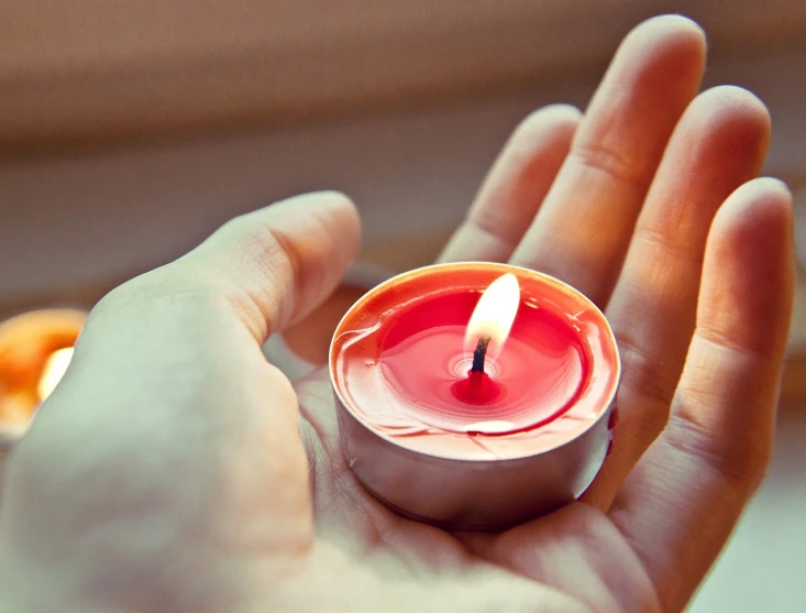 a person holding a lit candle in their hand, istockphoto, glowing red, immaculately detailed, instagram post