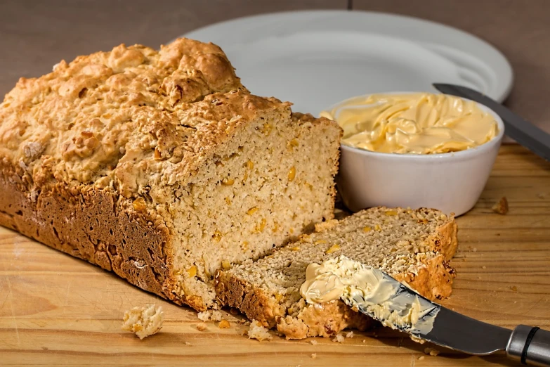 a loaf of bread sitting on top of a wooden cutting board, a picture, pixabay, bauhaus, mustard, the god of oatmeal, melted cheddar, with an intricate