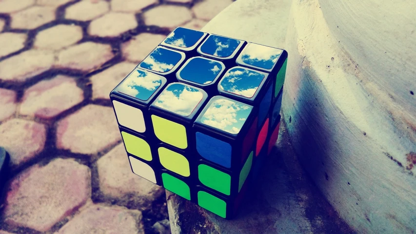 a rubik cube sitting on top of a sidewalk, a picture, cubo-futurism, cumulus, 🪔 🎨;🌞🌄, taken with my nikon d 3, (by tom purvis)