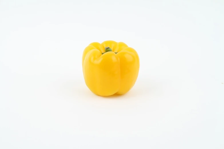 a yellow pepper on a white surface, minimalism, 5 5 mm photo