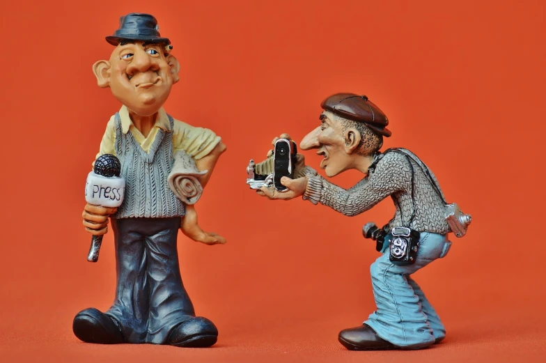a couple of figurines standing next to each other, pixabay contest winner, figurativism, giving an interview, old camera, caricaturist, don ramon