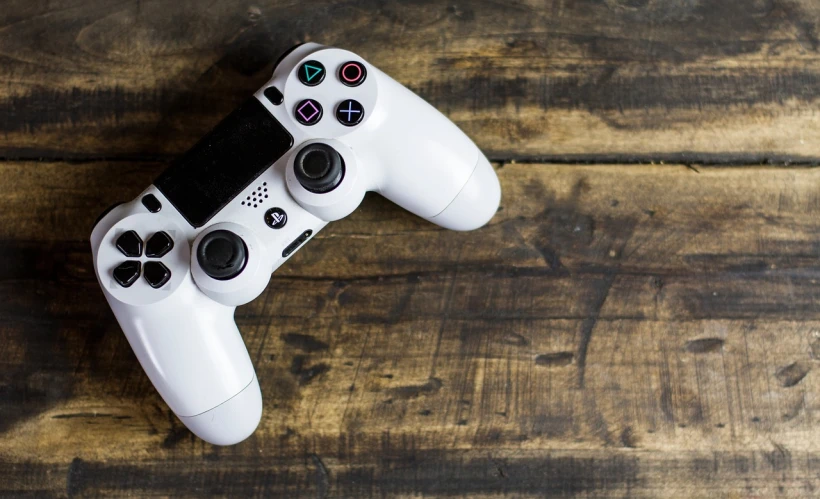 a video game controller sitting on top of a wooden table, by Dan Content, pexels, detailed white, shot on sony a 7, full length shot, gamin