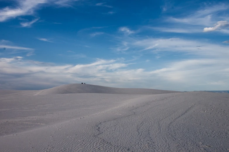 a man riding a snowboard down a snow covered slope, a photo, by Kristin Nelson, minimalism, in the desert beside the gulf, lonely family, usa-sep 20, white sand