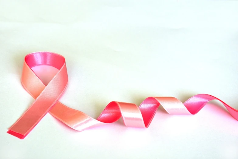 a pink ribbon laying on top of a white surface, a picture, by Juliette Wytsman, istockphoto, beautiful wallpaper, karim rashid, video footage