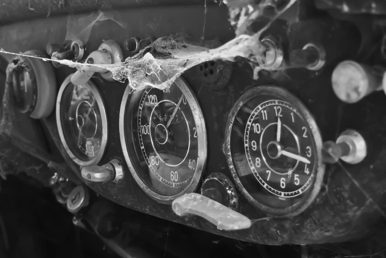 a black and white photo of a car dashboard, by Kurt Roesch, flickr, fine art, covered with cobwebs and dust, clocks, trio, crashed in roswell