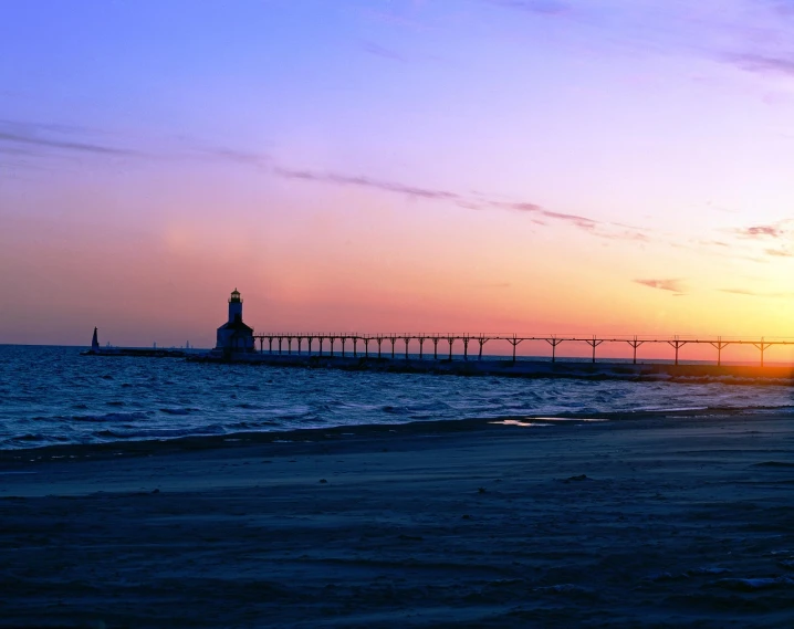 a lighthouse sitting on top of a sandy beach, by Jacob Burck, bridge, sunsetting color, port city, iu