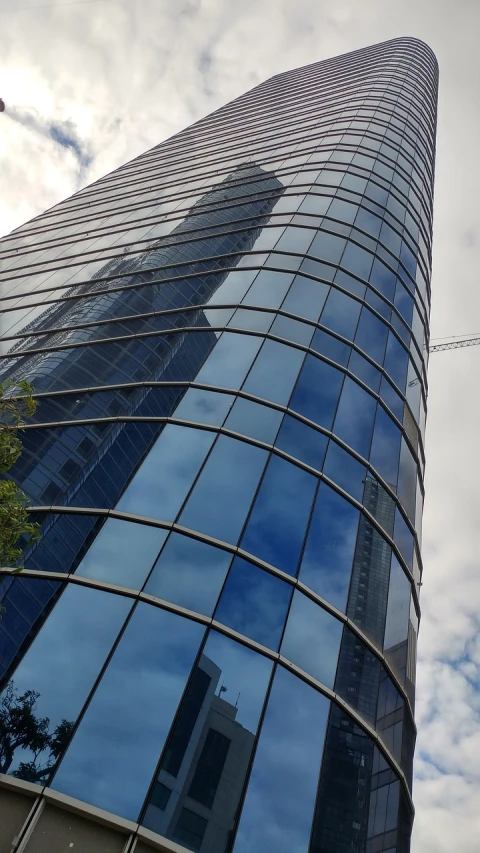 a very tall building with a lot of windows, rtx reflections, warsaw, curvy build, photo taken in 2018