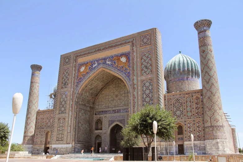 a large building with a fountain in front of it, by Kamāl ud-Dīn Behzād, shutterstock, hurufiyya, samarkand, massive decorated doors, side view from afar, a wide full shot