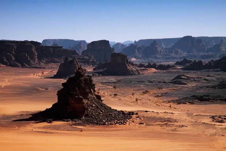 a large rock formation in the middle of a desert, les nabis, barsoom, pyramids in the desert, empty remote wilderness, scorched earth