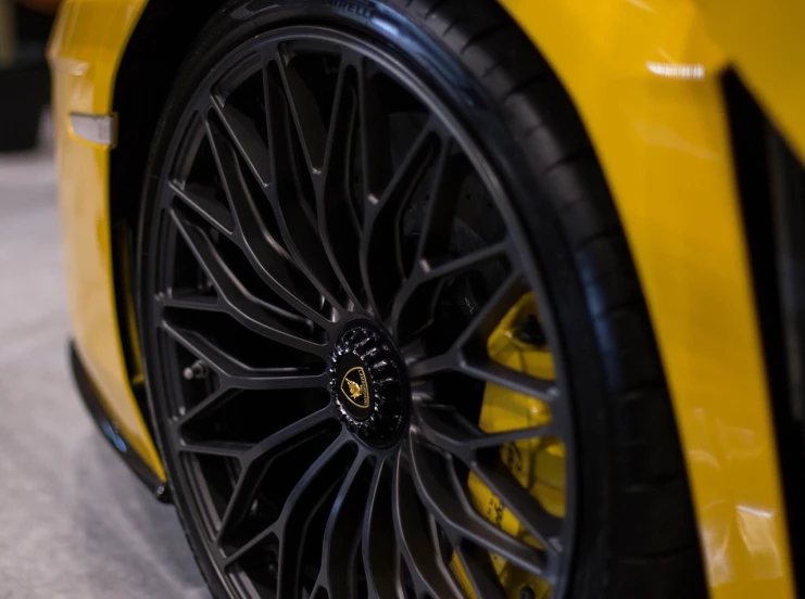 a close up of a yellow sports car on display, black wheel rims, commercial photography, micro detailing, white wheel rims