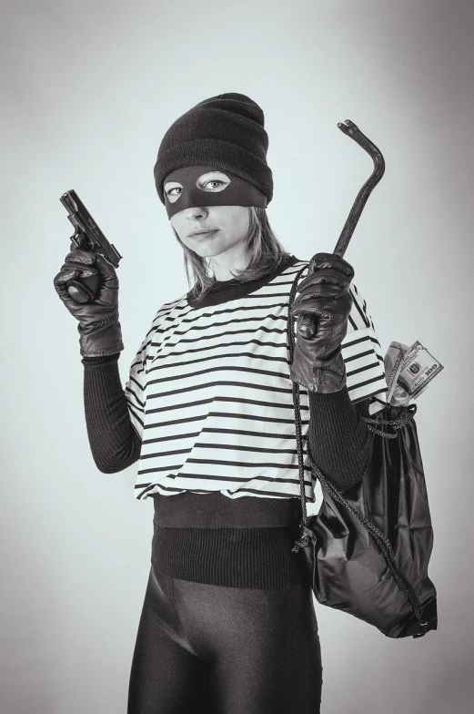 a black and white photo of a woman holding a gun, a black and white photo, by Emma Andijewska, shutterstock, fine art, bank robbery, superhero, stock photo, with a bunch of stuff