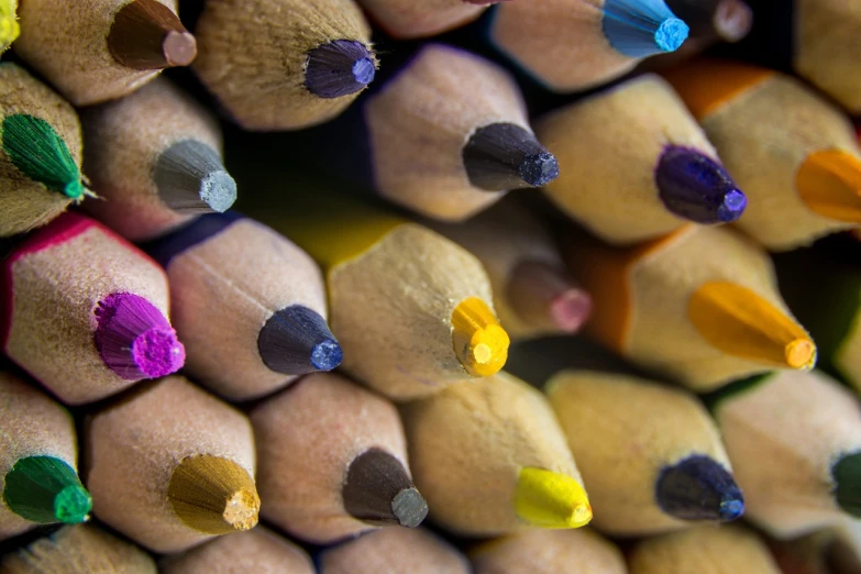 a close up of a bunch of colored pencils, a macro photograph, crayon art, subtle details, photo taken with sony a7r, small details, yellow and purple tones