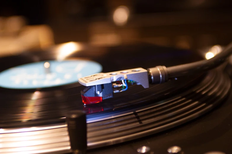 a close up of a record on a turntable, by Jay Hambidge, flickr, figuration libre, cable plugged into cyberdeck, night setting, profile close-up view, istock