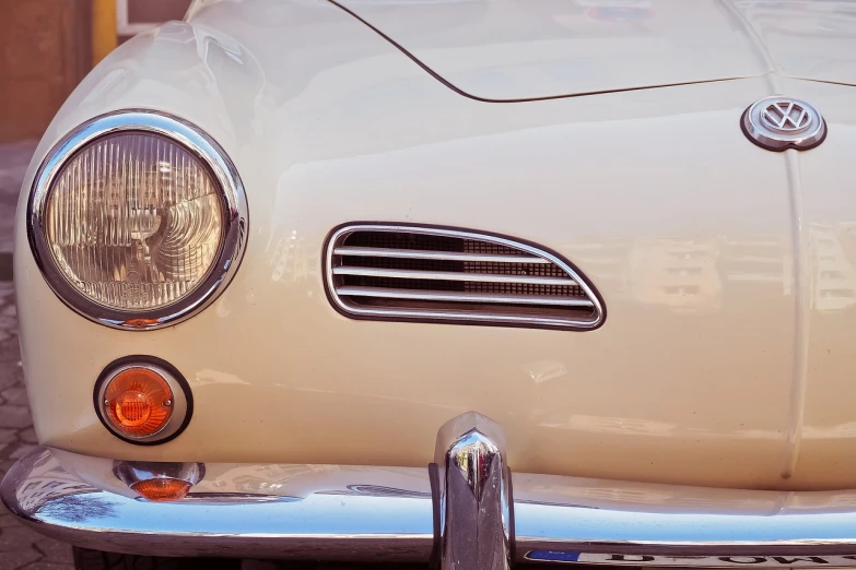 a close up of the front end of a white car, a photo, unsplash, fine art, in retro colors, carapace, speedster, brown and white color scheme