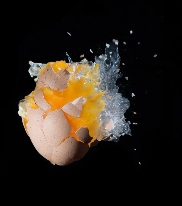 a broken egg sitting on top of a black surface, a picture, spectacular splatter explosion, high speed shutter, ivan shishk, peach