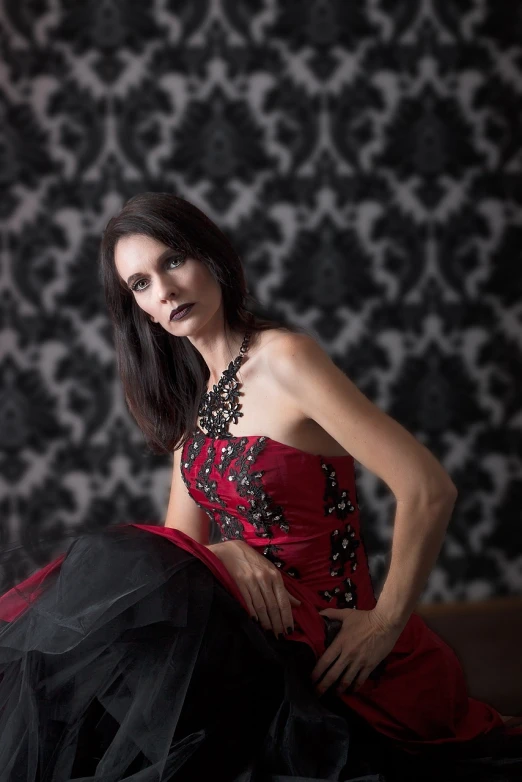 a woman in a red dress posing for a picture, a portrait, inspired by Flavia Blois, flickr, gothic art, professional studio photograph, red white and black, 40 years old women, wearing an evening gown