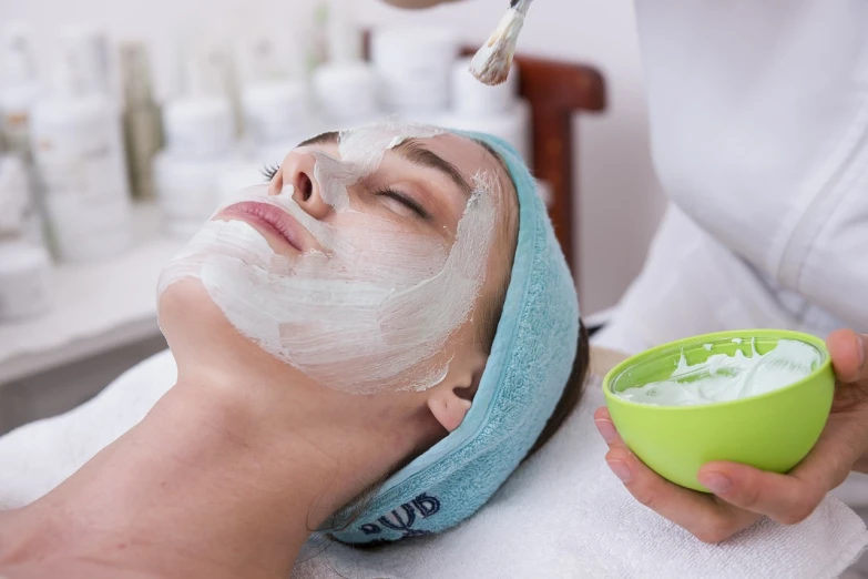 a woman getting a facial mask at a beauty salon, a photo, by Julian Allen, shutterstock, basic photo, true realistic image, stock photo