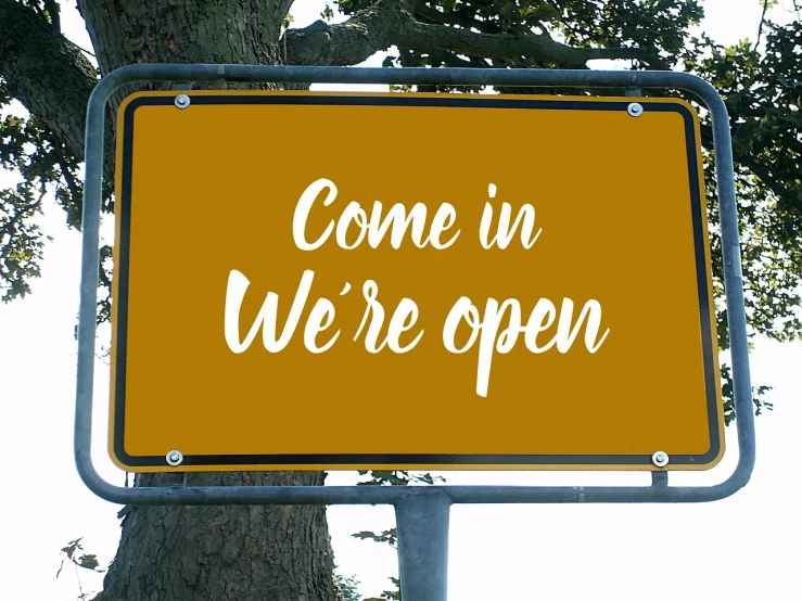 a yellow sign that says come in we're open, by Whitney Sherman, shutterstock, happening, 🦩🪐🐞👩🏻🦳, brown, 2 1 0 mm, in white lettering