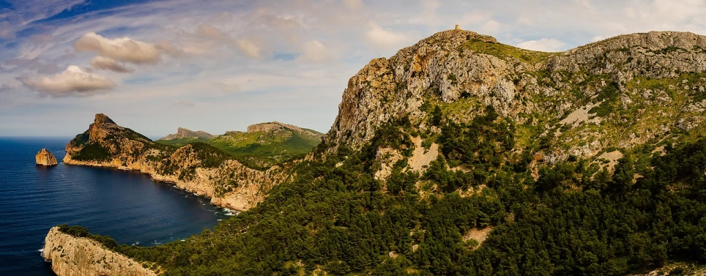 a large body of water sitting on top of a lush green hillside, by Maurice Esteve, pixabay, les nabis, ibiza, giant imposing mountain, shot on sony a 7 iii, banner