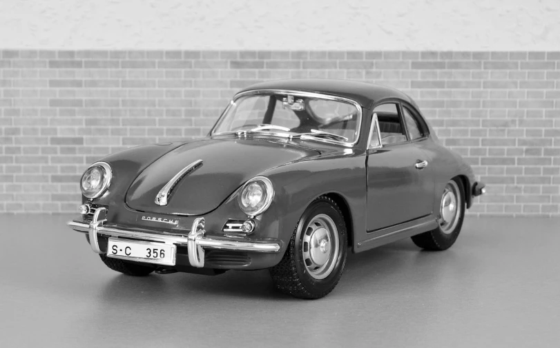 a black and white photo of a car in front of a brick wall, inspired by Kees Scherer, trending on pixabay, porsche 356, highly detailed toy, steel gray body, photo of a model