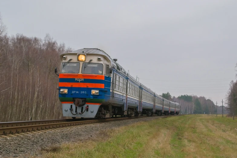 a large long train on a steel track, by Pavel Fedotov, shutterstock, dau-al-set, high quality photos, large blue engines, orange line, suburban