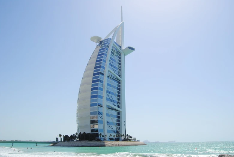 a tall building sitting on top of a sandy beach, pexels, hurufiyya, sails, huge futuristic building, dall - e 2, gulf