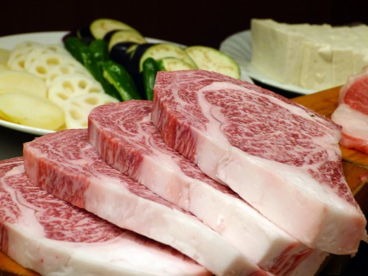 a bunch of meat sitting on top of a cutting board, a picture, sōsaku hanga, cream, shiro takatani, bovine, looking across the shoulder