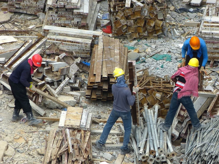 a group of men working at a construction site, by Bernard Meninsky, pexels, reclaimed lumber, piles of bodies, malaysian, blog-photo