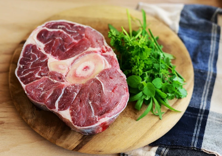 a piece of meat sitting on top of a wooden cutting board, a picture, shutterstock, mutton chops, clover, round thighs, herbs