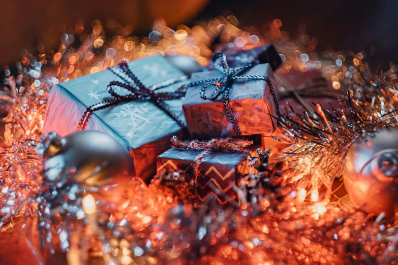 a pile of presents sitting on top of a christmas tree, by Adam Marczyński, pexels contest winner, digital art, blue and orange lighting, crypto, closeup portrait shot, floating embers