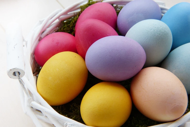 a basket filled with colored eggs sitting on top of a table, a pastel, by Juan O'Gorman, flickr, close-up photo, grain”