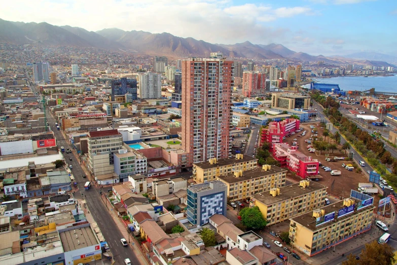 an aerial view of a city with mountains in the background, by Maximilian Cercha, shutterstock, in chuquicamata, city high-rise, koyaanisqatsi, market