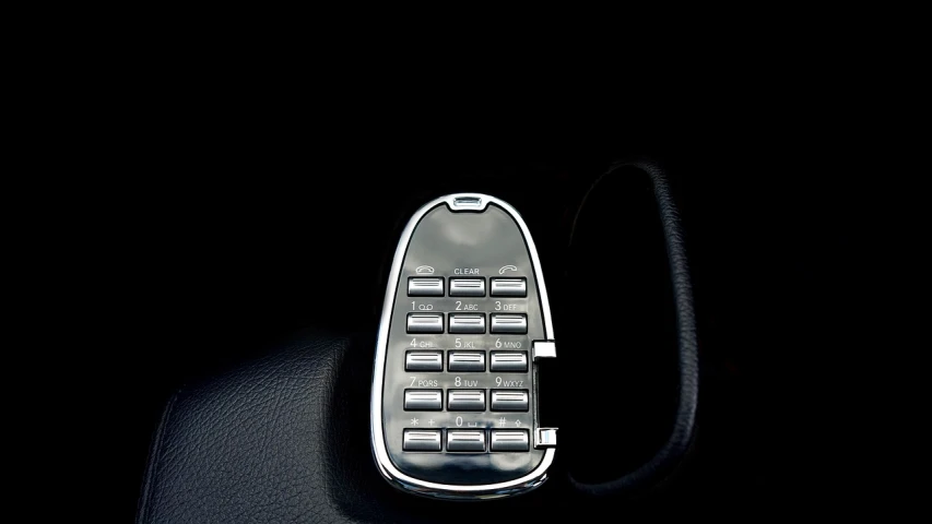 a close up of a remote control in a car, a stock photo, by Matthias Stom, les automatistes, shiny silver, 1759, telephone, deep contrast