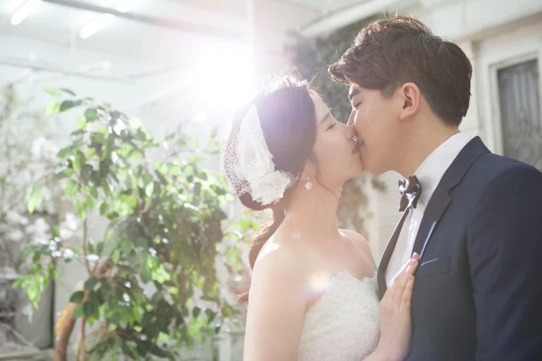 a man in a tuxedo kissing a woman in a wedding dress, a picture, inspired by Kim Hwan-gi, tumblr, romanticism, sunny lighting, b - roll, siwoo kim, indoor picture