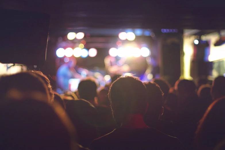 a crowd of people watching a band on stage, pexels, calm night. over shoulder shot, istock, low resolution, blur : - 2