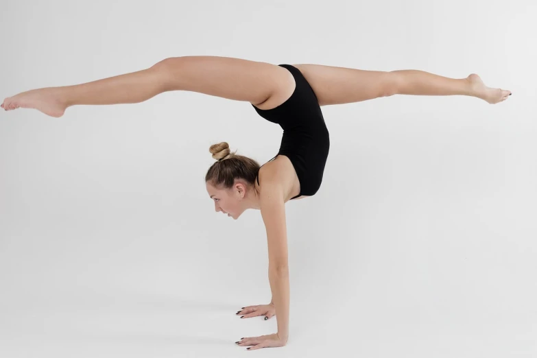 a woman in a black leoper leoper leoper leoper leoper leoper leoper leoper leoper leoper leoper leo, a picture, inspired by Elizabeth Polunin, shutterstock, arabesque, acrobatic pose, on a white table, benjamin vnuk, perfect symmetry