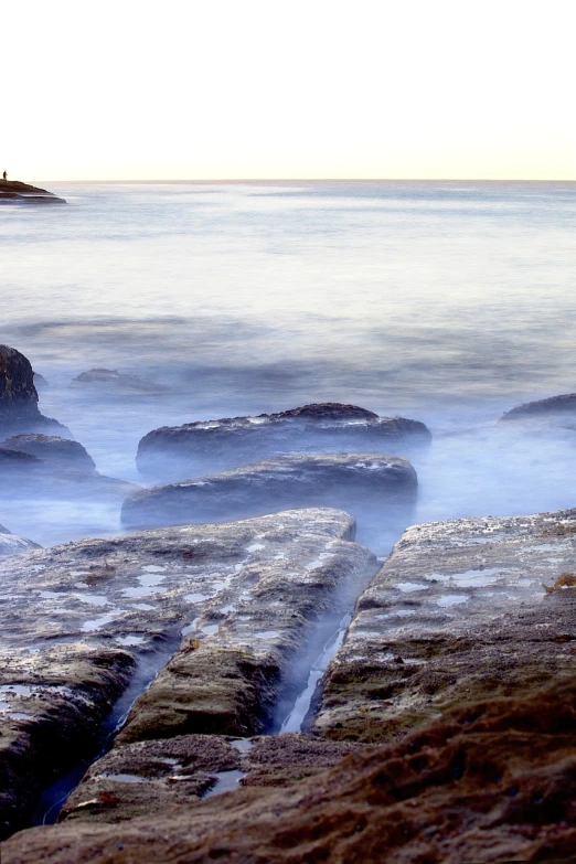 a couple of rocks sitting on top of a beach, a picture, by John Murdoch, water mists, manly, clean long lines, morning detail