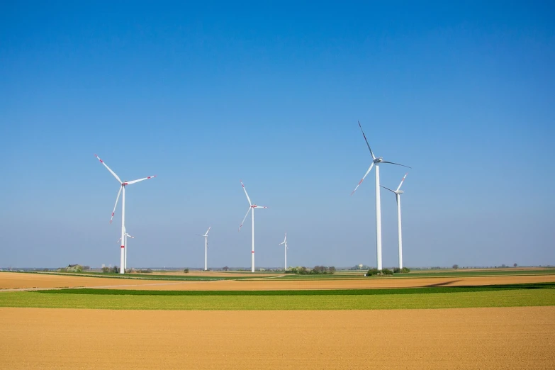 a group of wind turbines sitting in the middle of a field, a stock photo, by Thomas Häfner, shutterstock, lower saxony, landscape of flat wastelands, half and half, maintenance photo