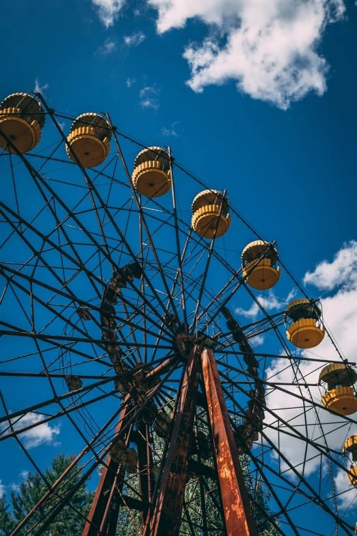 a ferris wheel against a blue sky with clouds, pexels, bauhaus, an abandoned old, magical soviet town, black and yellow colors, summer day